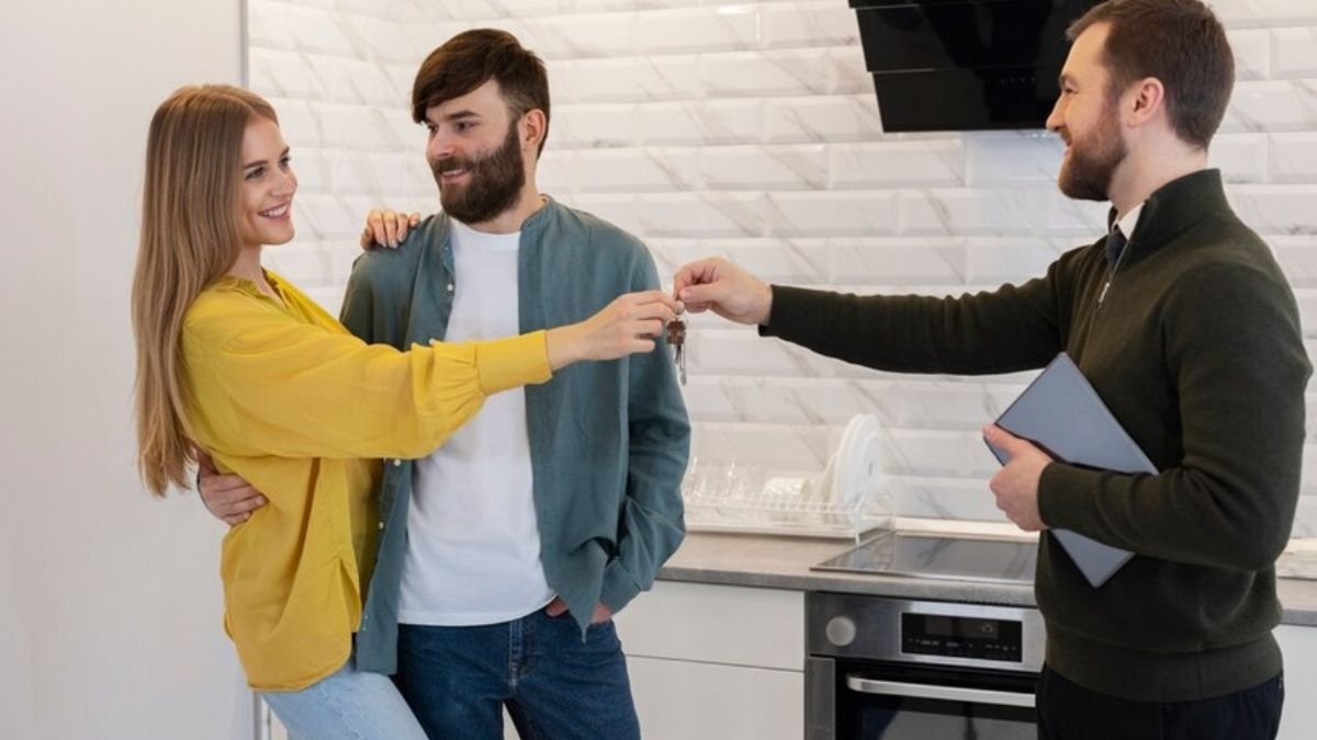 Male real estate agent doing business and showing house to potential buying couple